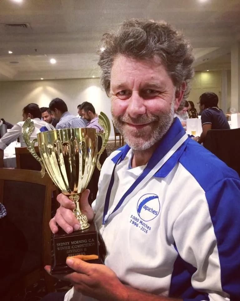 Tim 'Webko' Booth holding a Sydney Morning C.A. Winter Competition trophy, wearing an Apaches shirt marking 1000 matches from 1996 to 2016